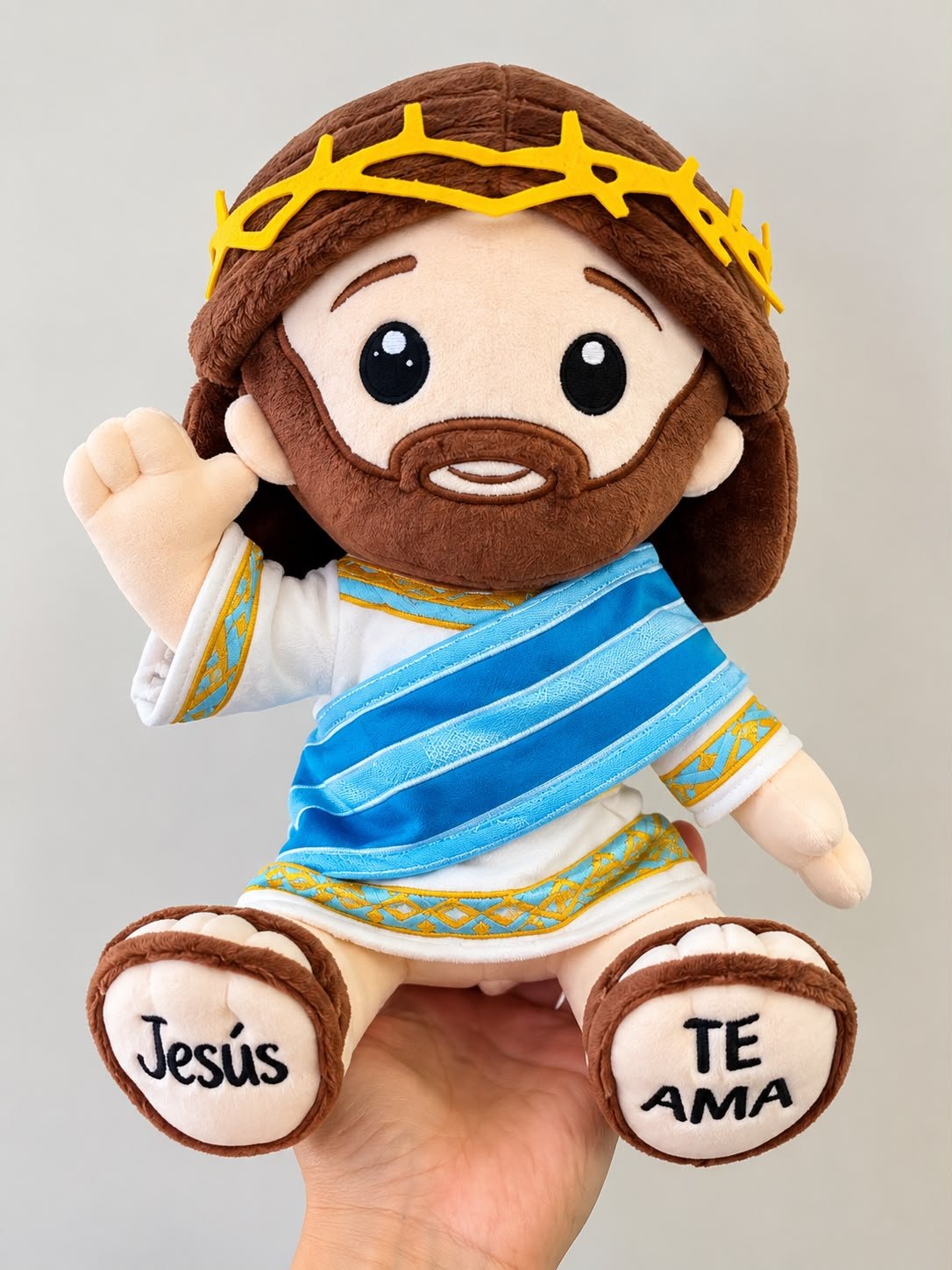 Muñeco original de Jesús con corona amarilla, manto azul y Jesús te ama bordado en los pies